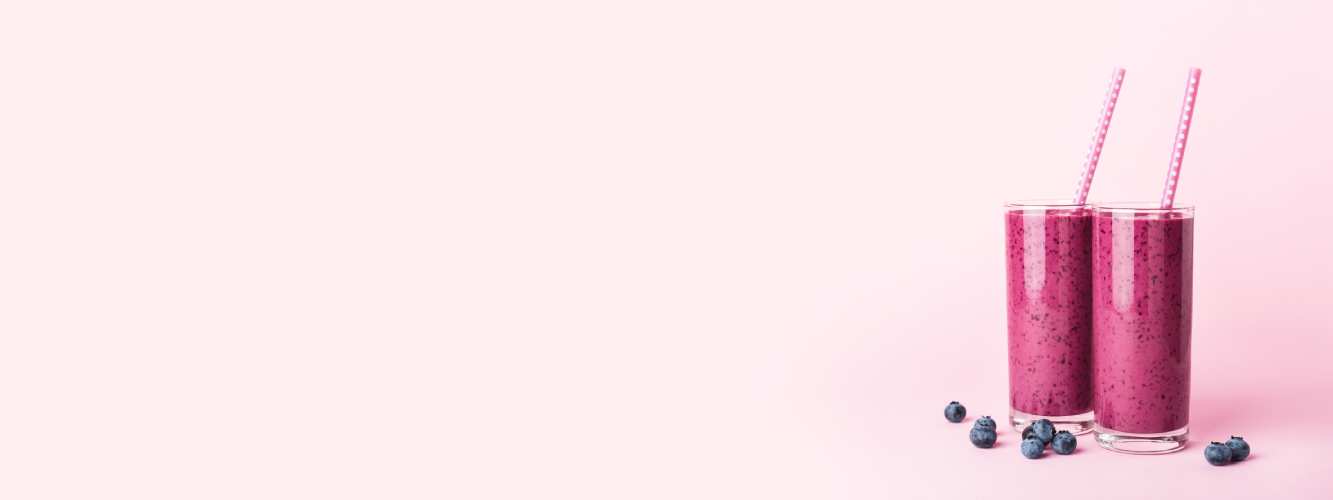 nutritional shakes on a pink background with blueberries
